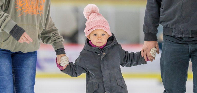 Enfant avec ses parents à la patinoire