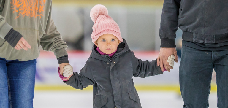 Enfant avec ses parents à la patinoire