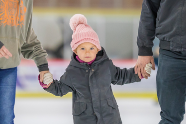 Enfant avec ses parents à la patinoire